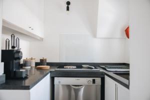 a kitchen with white cabinets and a stove top oven at Santi Medici Apartment in Terlizzi