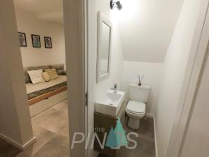 a bathroom with a toilet and a sink and a bed at Departamento Entre Pinos in San Carlos de Bariloche +2 photos