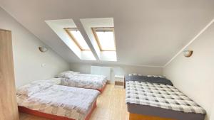 a attic bedroom with two beds and a skylight at Pokoje Gościnne R10 in Rewa