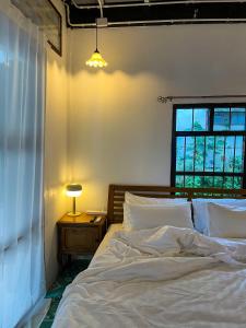 a bedroom with a white bed and a window at The Ordinary 8 in Surat Thani