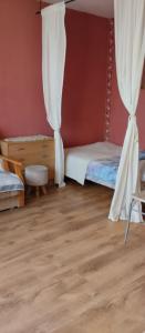 a bedroom with a bed and a curtain and a wooden floor at Apartament z baldachimem i pięknym widokiem Olsztyna in Olsztyn