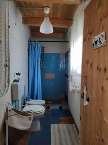 y baño con aseo y ducha azul. en Casa Francesca Romana, en Marina di Noto