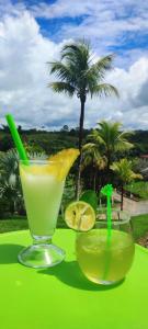 two drinks on a green table with a palm tree at hotel palma dorada in Doradal