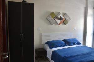 a bedroom with a bed and a black cabinet at Aconchegante 3 quartos na Prainha in Arraial do Cabo