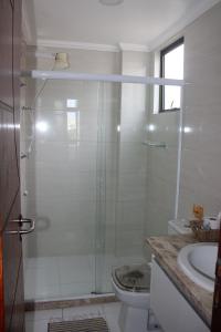 y baño con ducha, aseo y lavamanos. en Aconchegante 3 quartos na Prainha, en Arraial do Cabo