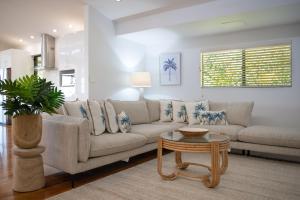 una sala de estar con un sofá y una mesa en Seaview On Airlie, en Airlie Beach