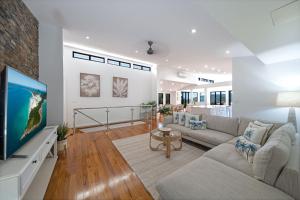 Una sala de estar con un sofá y un televisor. en Seaview On Airlie, en Airlie Beach 16 fotos más