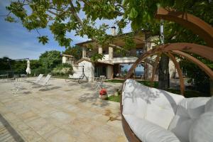 a patio with white chairs and a building at Villa Clara in Assisi