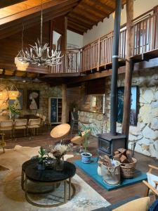 a living room with a fireplace and a stone wall at Le Petit Chateau Homestead Bridgetown in Bridgetown