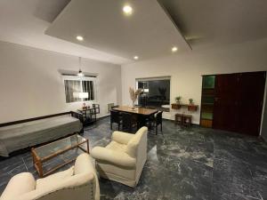 sala de estar con sofá, sillas y mesa en Tu alojamiento en Santiago del Estero en Santiago del Estero