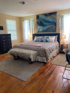 a bedroom with a bed and a painting on the wall at Cozy home, King bed, 3 bedrooms,close to downtown beaches towncenter in Jacksonville