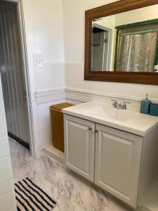 a white bathroom with a sink and a mirror at Cozy home, King bed, 3 bedrooms,close to downtown beaches towncenter in Jacksonville