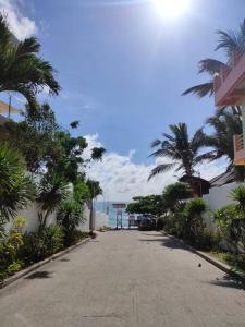 una calle vacía con palmeras y el océano en Private Townhouse (Serenia Homestay), en San Juan
