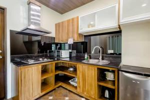 a kitchen with wooden cabinets and a sink at Private Townhouse (Serenia Homestay) in San Juan