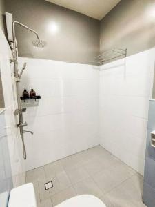a white bathroom with a toilet and a shower at Private Townhouse (Serenia Homestay) in San Juan
