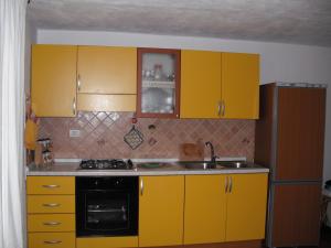 una cucina con armadi gialli e piano cottura di Casa Vacanze Il Pino a Cannigione