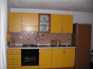 a kitchen with yellow cabinets and a stove at Casa Vacanze Il Pino in Cannigione +9 photos