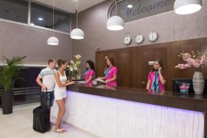 a group of people standing at a reception counter at New Famagusta Hotel & Suites in Ayia Napa +37 photos