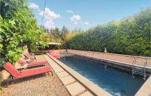 una piscina con 2 sillas rojas y árboles en Pet Friendly Home In Aspiran With Outdoor Swimming Pool, en Aspiran