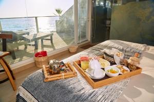 uma bandeja de comida numa cama com pequeno-almoço em Maressenza Night Spa em Viña del Mar