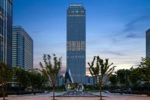 a tall building with a sculpture in front of it at Somerset Taihu New City CBD Wuxi in Wuxi