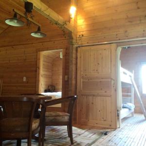 - une salle à manger avec une table et des chaises dans une cabine dans l'établissement Log Cottage be with nature, à Furano