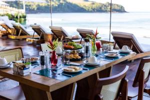 a table with food on it with a view of the ocean at Duke Beach Hotel Maresias in Maresias
