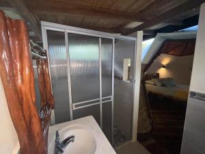 a bathroom with a sink and a shower with a bed at Mi casa es tu casa Glamping in Capurganá