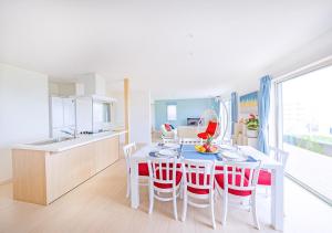 - une cuisine et une salle à manger avec une table et des chaises dans l'établissement ヴィラアマルフィ パームスプリングス宮古島リゾート, à Île Miyako