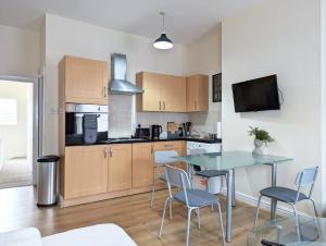 a kitchen with a table and chairs in a room at Lovely Studio In Anfield Near Centre Free Parking in Liverpool