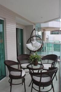 un grupo de sillas y una mesa en el balcón en Confortável apartamento na Praia do Forte, en Cabo Frío