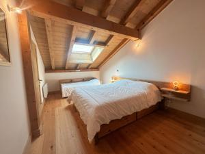 een slaapkamer met een groot bed en een houten plafond bij Appartement Samoëns, 4 pièces, 8 personnes - FR-1-624-136 in Samoëns