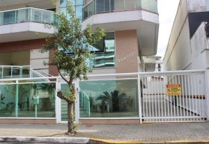 a tree on a sidewalk in front of a building at Confortável apartamento na Praia do Forte in Cabo Frio