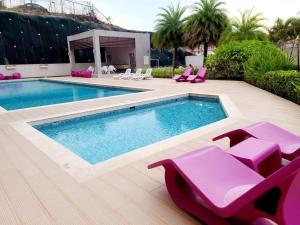 a swimming pool with pink lounge chairs and a swimming pool at Amazing Apt. Close to the City in Panama City