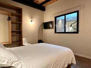 a bedroom with a white bed and a window at Casa Raffaello in Mexico City