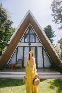 a woman in a yellow dress standing in front of a house at Bai Dinh Garden Resort & Spa in Ninh Binh