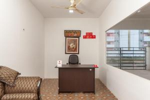 een kantoor met een stoel, een bureau en een plafondventilator bij Hotel Le Mint OMR in Chennai