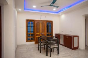 uma sala de jantar com uma mesa e cadeiras e um tecto em Hotel Le Mint OMR em Chennai