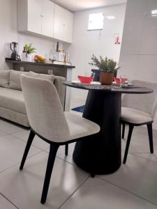 a table and chairs in a living room with a kitchen at Flat Ideal para conexão 5 in Guarulhos