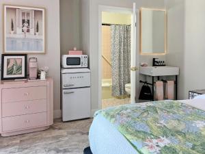 a bedroom with a bed and a sink and a microwave at The Inn On Main in Chincoteague