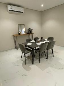 a dining room with a black table and chairs at AMA APARTMENT in Ar Rass