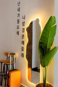 une pièce avec une plante et un panneau sur le mur dans l'établissement Tuấn An Hotel, à Đà Lạt
