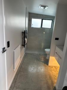a small bathroom with a toilet and a window at Modern Two bedroom Oasis in Whangamata