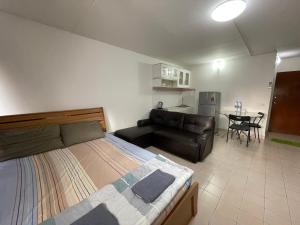 a bedroom with a bed and a couch and a table at Popular The best muangthongthani 日常房间公寓 in Ban Bang Phang