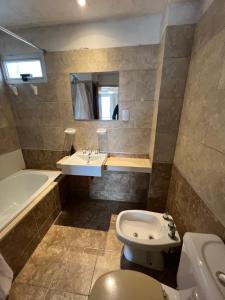 uma casa de banho com um lavatório, um WC e uma banheira em Garden Point Luxury Apartments em San Miguel de Tucumán
