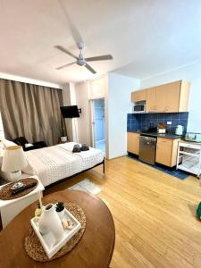 a room with a bed and a table and a kitchen at Studio in Darling Point in Sydney