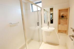 a white bathroom with a sink and a shower at Apt 8 'Aquilla' @ Bay View Centro, Dunsborough in Dunsborough