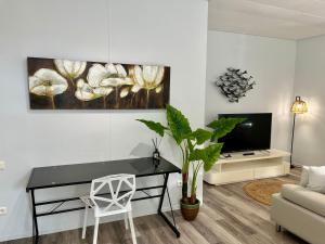 a living room with a black desk and a tv at Tiaki Guesthouse - Cozy Modern Studio - 5min drive from the beach and Punaauia center in Punaauia