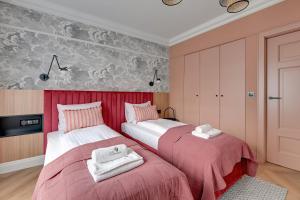 2 łóżka w pokoju z różowymi ścianami w obiekcie Havana Premium Family Stay by Lion Apartments Sopot w mieście Sopot