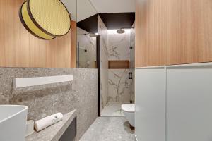 a bathroom with a toilet and a sink and a shower at Lion Apartments - Havana Premium Family Stay in Sopot